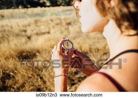 Over shoulder view of woman using compass View Large Photo Image Stock Image - Over shoulder view of woman using compass. Fotosearch