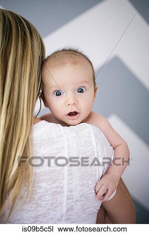 Over the shoulder portrait of cute baby boy in mother's arms View Large Photo Image Stock Image - Over the shoulder portrait of cute baby boy in mother's arms. Fotosearch