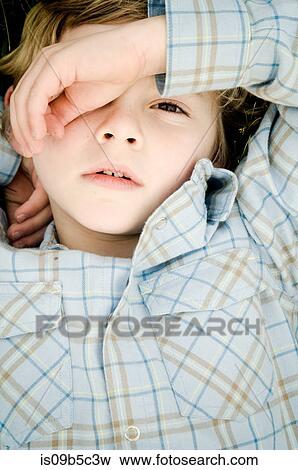Overhead portrait of boy covering eye with hand View Large Photo Image Stock Photo - Overhead portrait of boy covering eye with hand. Fotosearch