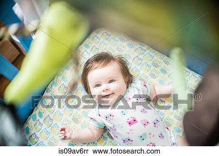 Overhead view of baby girl lying in crib smiling View Large Photo Image Stock Photography - Overhead view of baby girl lying in crib smiling. Fotosearch