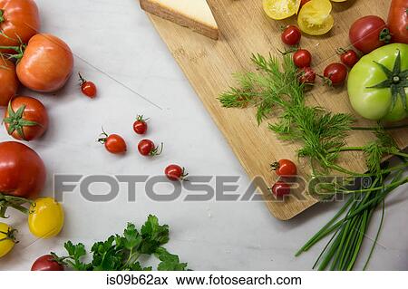 Overhead view of chopping board with heirloom tomatoes, cheese and dill View Large Photo Image Stock Photo - Overhead view of chopping board with heirloom tomatoes, cheese and dill. Fotosearch
