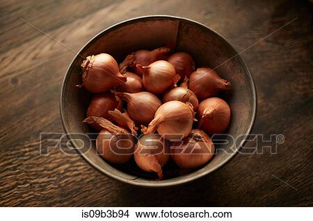 Picture - Overhead view of fresh whole shallots in bowl. Fotosearch