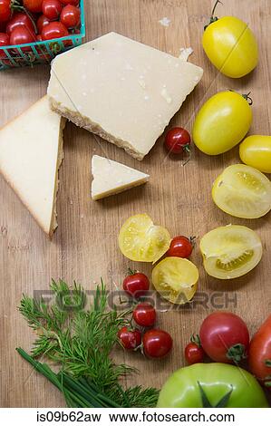 Overhead view of heirloom tomatoes, cheese and dill on chopping board View Large Photo Image Stock Photo - Overhead view of heirloom tomatoes, cheese and dill on chopping board. Fotosearch