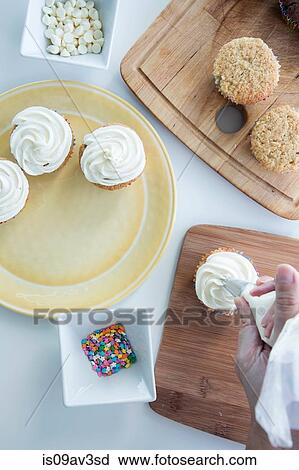 Overhead view of person icing cupcake View Large Photo Image Stock Image - Overhead view of person icing cupcake. Fotosearch