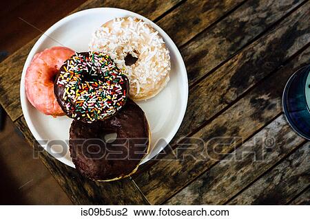 Stock Image - Overhead view of table and plate of doughnut holes. Fotosearch