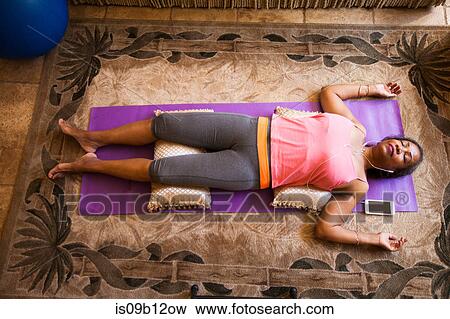 Overhead view of woman lying down meditating View Large Photo Image Stock Photo - Overhead view of woman lying down meditating. Fotosearch