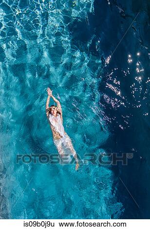 Overhead view of woman swimming on back in swimming pool View Large Photo Image Stock Photograph - Overhead view of woman swimming on back in swimming pool. Fotosearch