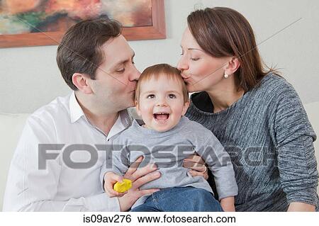 Parents kissing son on head at home View Large Photo Image Stock Photograph - Parents kissing son on head at home. Fotosearch
