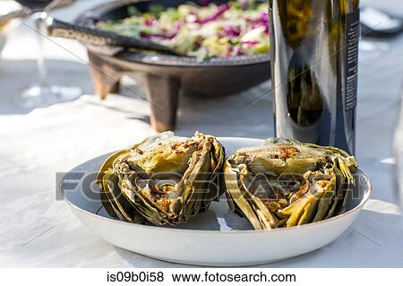Party garden table with wine bottle and baked artichokes View Large Photo Image Stock Photo - Party garden table with wine bottle and baked artichokes. Fotosearch