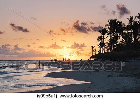 Stock Image - People on beach at sunset, Bavaro Beach, Punta Cana, Dominican Republic. Fotosearch