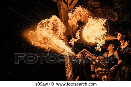 Stock Image - Performers fire breathing in urban area. Fotosearch
