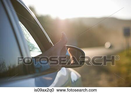 Stock Image - Person resting feet on window of vehicle. Fotosearch