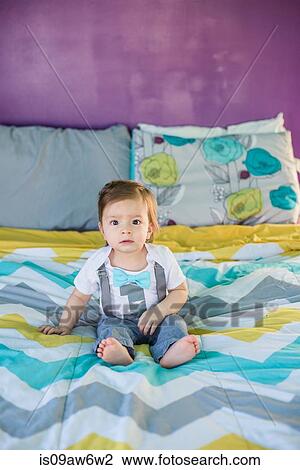 Portrait of baby boy sitting on bed View Large Photo Image Stock Image - Portrait of baby boy sitting on bed. Fotosearch