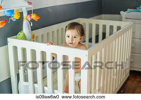 Portrait of baby boy standing looking out from crib View Large Photo Image Stock Image - Portrait of baby boy standing looking out from crib. Fotosearch