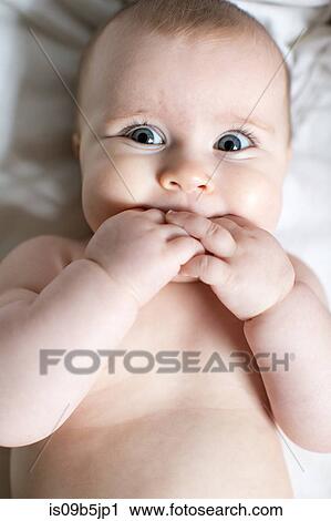 Portrait of baby girl, fingers in mouth, overhead view View Large Photo Image Stock Image - Portrait of baby girl, fingers in mouth, overhead view. Fotosearch