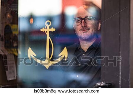 Portrait of barman looking through public house window, Brooklyn, New York, USA View Large Photo Image Stock Photography - Portrait of barman looking through public house window, Brooklyn, New York, USA. Fotosearch