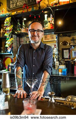 Portrait of barman with cocktail glass at public house counter View Large Photo Image Picture - Portrait of barman with cocktail glass at public house counter. Fotosearch