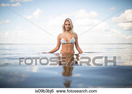 Stock Photograph - Portrait of beautiful woman with long blond hair in sea, Santa Rosa Beach, Florida, USA. Fotosearch