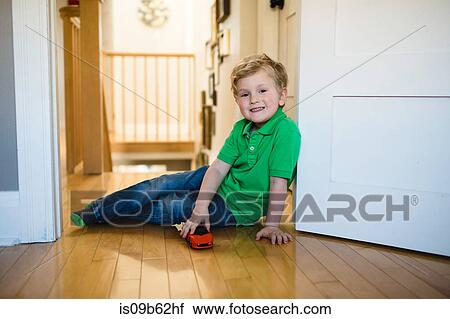 Portrait of boy with toy car sitting on floor View Large Photo Image Stock Image - Portrait of boy with toy car sitting on floor. Fotosearch