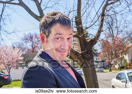 Portrait of business man in residential area pulling face at camera smiling View Large Photo Image Stock Photo - Portrait of business man in residential area pulling face at camera smiling. Fotosearch