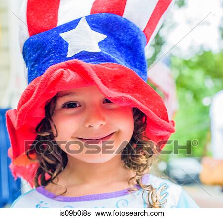 Stock Photograph - Portrait of cute girl wearing stars and stripes hat on Independence Day. Fotosearch