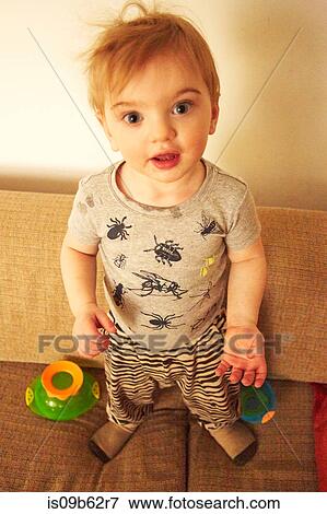 Portrait of cute male toddler standing on sofa View Large Photo Image Stock Photo - Portrait of cute male toddler standing on sofa. Fotosearch