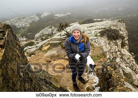 Portrait of female hiker with her dog holding snowball in misty mountains, Spain View Large Photo Image Stock Photo - Portrait of female hiker with her dog holding snowball in misty mountains, Spain. Fotosearch