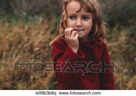 Portrait of girl chewing long grass in field View Large Photo Image Stock Photography - Portrait of girl chewing long grass in field. Fotosearch