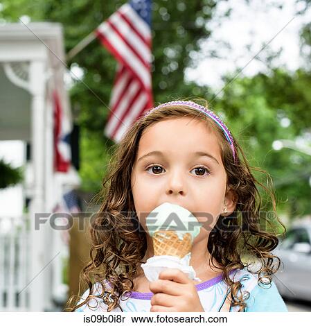 Portrait of girl eating ice cream cone on Independence Day View Large Photo Image Stock Photography - Portrait of girl eating ice cream cone on Independence Day. Fotosearch