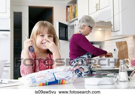 Portrait of girl holding a whisk whilst cooking with grandmother View Large Photo Image Stock Photograph - Portrait of girl holding a whisk whilst cooking with grandmother. Fotosearch