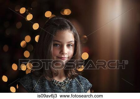Portrait of girl in front of christmas tree looking at camera smiling View Large Photo Image Stock Image - Portrait of girl in front of christmas tree looking at camera smiling. Fotosearch