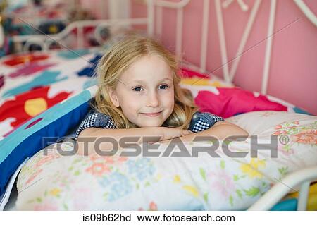Portrait of girl lying on bed View Large Photo Image Stock Image - Portrait of girl lying on bed. Fotosearch