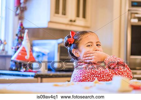 Portrait of girl with hand covering her mouth in kitchen View Large Photo Image Stock Image - Portrait of girl with hand covering her mouth in kitchen. Fotosearch