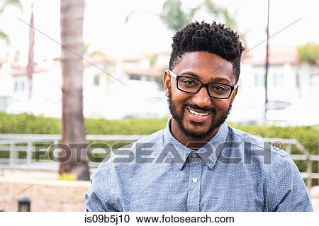 Portrait of happy young man in spectacles on rail station platform View Large Photo Image Stock Image - Portrait of happy young man in spectacles on rail station platform. Fotosearch