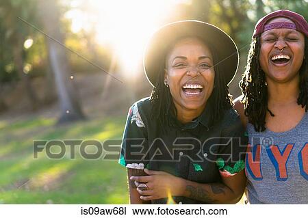 Stock Image - Portrait of lesbian couple, laughing. Fotosearch