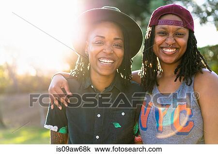 Stock Image - Portrait of lesbian couple, smiling. Fotosearch