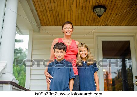 Portrait of male and female elementary school twins with mother outside home porch View Large Photo Image Stock Image - Portrait of male and female elementary school twins with mother outside home porch. Fotosearch