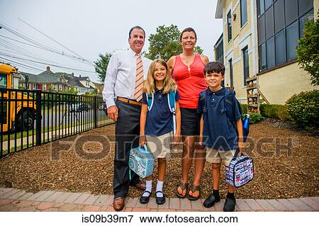 Portrait of male and female twins with parents outside elementary school View Large Photo Image Stock Photo - Portrait of male and female twins with parents outside elementary school. Fotosearch