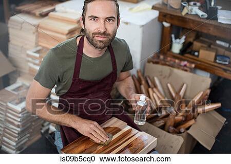 Portrait of man applying wood stain to chopping board in factory View Large Photo Image Stock Image - Portrait of man applying wood stain to chopping board in factory. Fotosearch