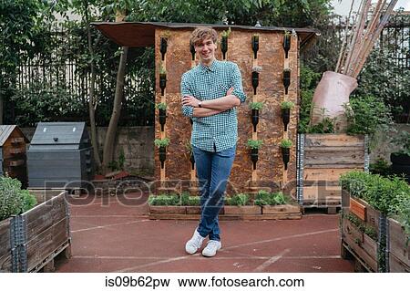 Portrait of man in garden, arms crossed looking at camera smiling View Large Photo Image Stock Photo - Portrait of man in garden, arms crossed looking at camera smiling. Fotosearch