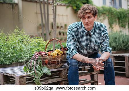 Portrait of man sitting in garden looking at camera smiling View Large Photo Image Stock Image - Portrait of man sitting in garden looking at camera smiling. Fotosearch