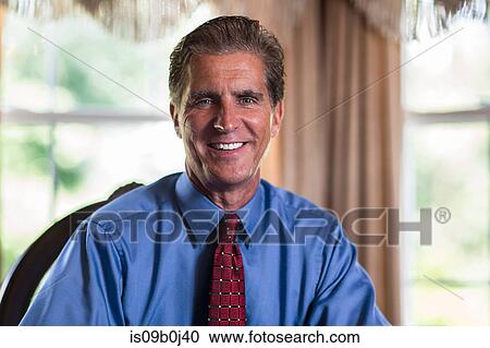 Stock Image - Portrait of mature businessman at home. Fotosearch