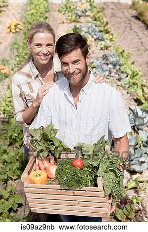 Portrait of mature couple in garden, holding crate of fresh vegetables View Large Photo Image Stock Image - Portrait of mature couple in garden, holding crate of fresh vegetables. Fotosearch