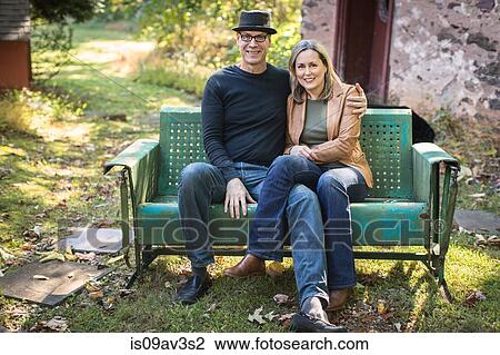 Portrait of mature couple, sitting on bench, outdoors View Large Photo Image Stock Image - Portrait of mature couple, sitting on bench, outdoors. Fotosearch
