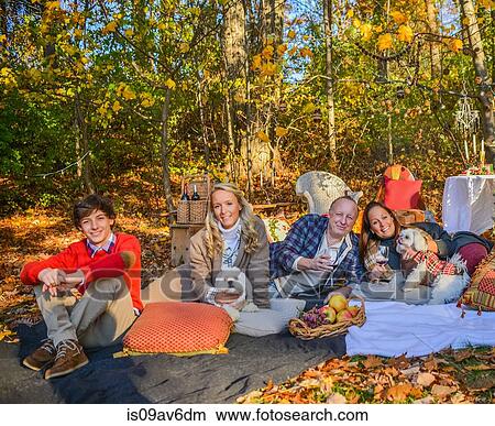 Portrait of mature couple with dogs, teenage and adult children relaxing on picnic blanket in woods View Large Photo Image Picture - Portrait of mature couple with dogs, teenage and adult children relaxing on picnic blanket in woods. Fotosearch