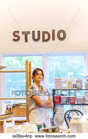 Stock Photography - Portrait of mature female potter in ceramic studio. Fotosearch