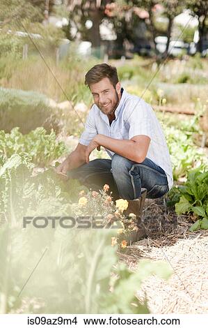 Portrait of mature man crouching in garden View Large Photo Image Picture - Portrait of mature man crouching in garden. Fotosearch