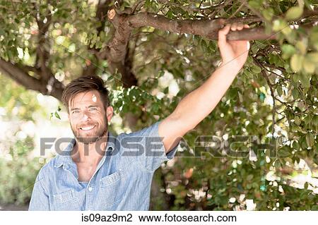 Portrait of mature man in garden holding tree branch View Large Photo Image Stock Image - Portrait of mature man in garden holding tree branch. Fotosearch