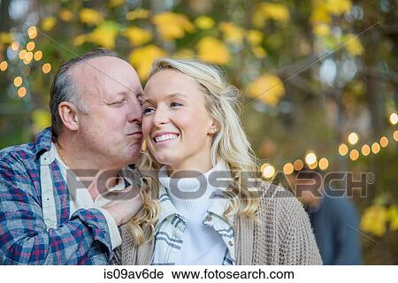 Portrait of mature man kissing adult daughter View Large Photo Image Stock Image - Portrait of mature man kissing adult daughter. Fotosearch