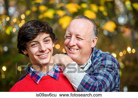 Portrait of mature man with hands on teenage sons shoulder in woods View Large Photo Image Stock Photograph - Portrait of mature man with hands on teenage sons shoulder in woods. Fotosearch